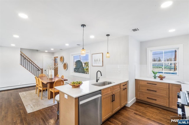 kitchen featuring decorative light fixtures, a baseboard radiator, sink, stainless steel dishwasher, and kitchen peninsula