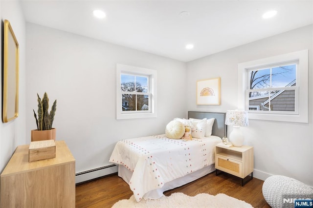 bedroom featuring multiple windows, a baseboard radiator, and dark hardwood / wood-style floors