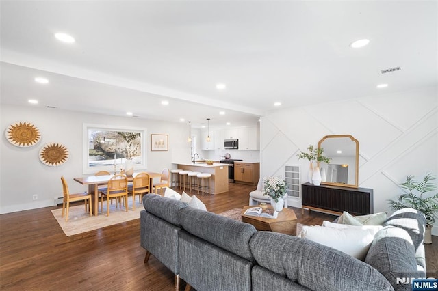 living room with sink and dark wood-type flooring