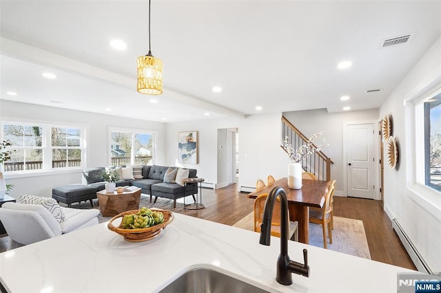 dining room with dark wood-type flooring and baseboard heating