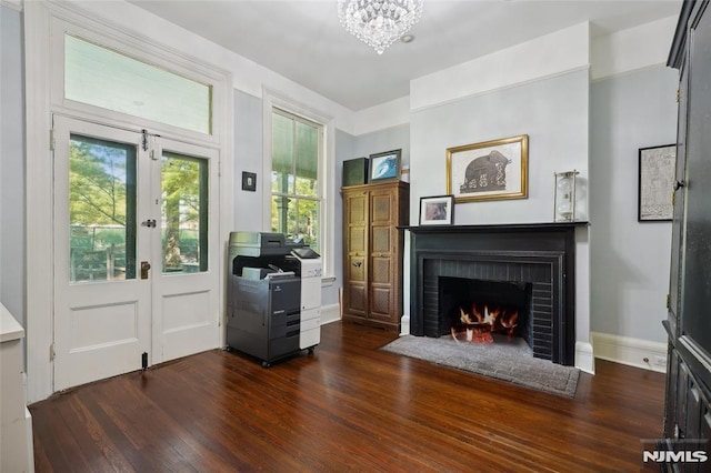 entryway with a fireplace, dark hardwood / wood-style flooring, an inviting chandelier, and a wealth of natural light