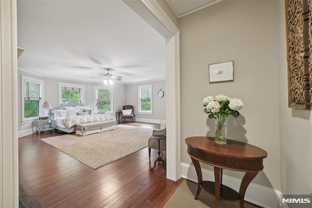 bedroom featuring dark wood-type flooring, ceiling fan, and crown molding