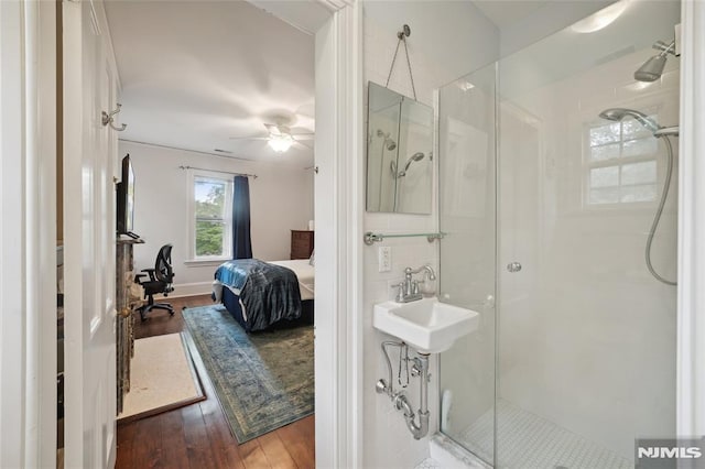 bathroom with walk in shower, hardwood / wood-style flooring, ceiling fan, and sink