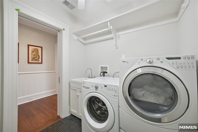 laundry area featuring dark hardwood / wood-style floors, cabinets, sink, and washing machine and clothes dryer