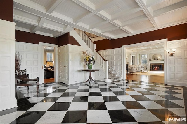 foyer entrance featuring crown molding, beamed ceiling, and coffered ceiling