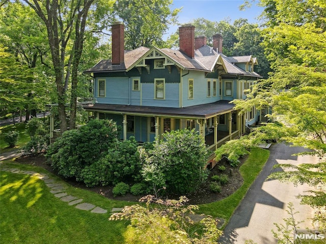 back of property featuring covered porch