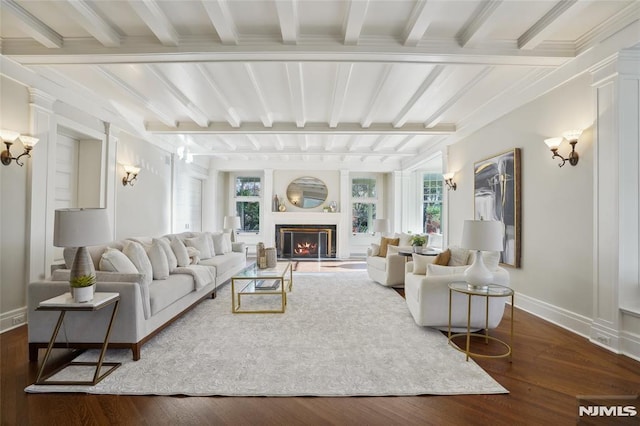 living room with beamed ceiling, crown molding, and dark wood-type flooring