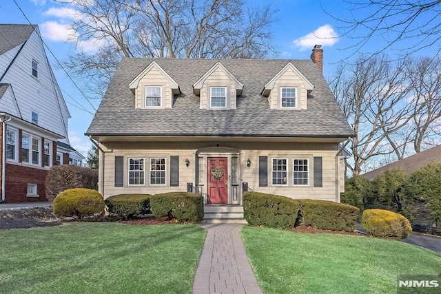 cape cod home featuring a front lawn