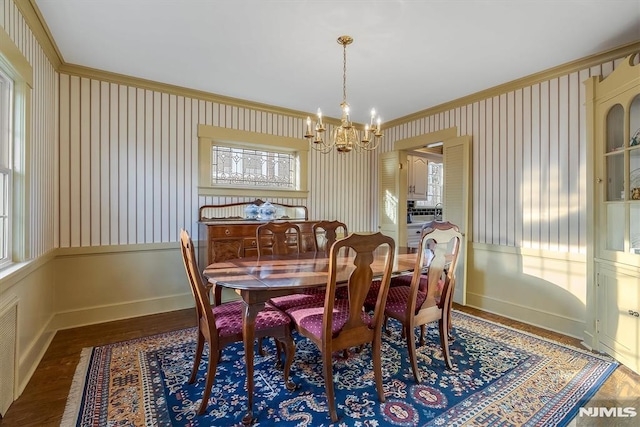 dining room with ornamental molding, a notable chandelier, and dark hardwood / wood-style flooring