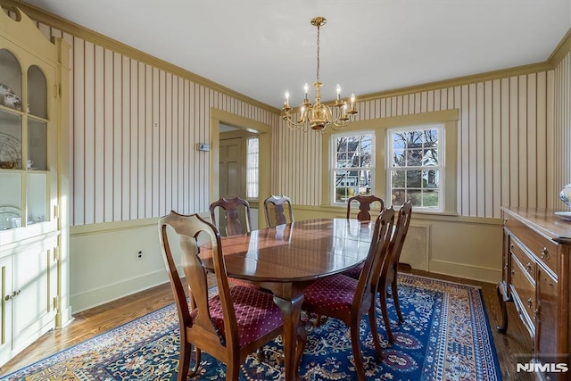 dining space featuring ornamental molding, dark hardwood / wood-style floors, and a chandelier