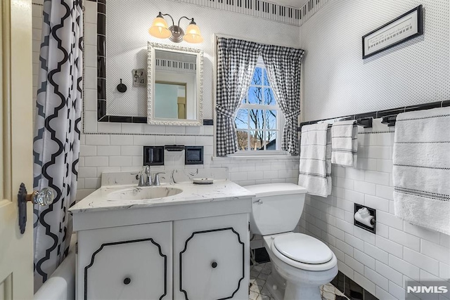 bathroom featuring tile walls, toilet, a shower with curtain, and vanity