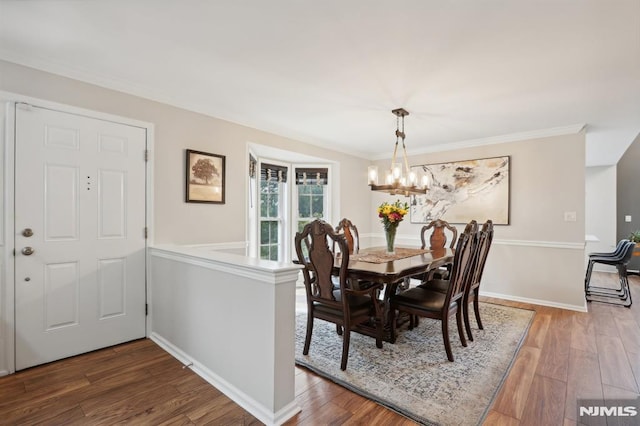 dining area featuring an inviting chandelier, crown molding, and wood-type flooring