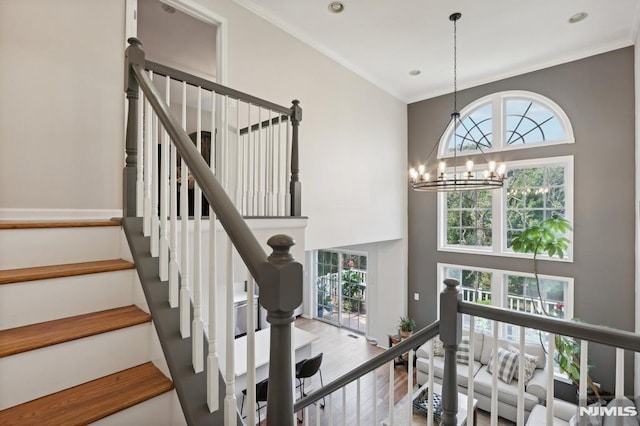 stairway featuring ornamental molding, hardwood / wood-style floors, and a chandelier