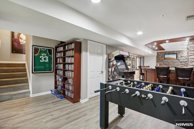 playroom with light hardwood / wood-style flooring and indoor bar