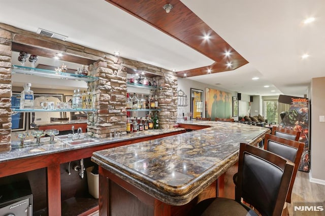 bar with light hardwood / wood-style flooring