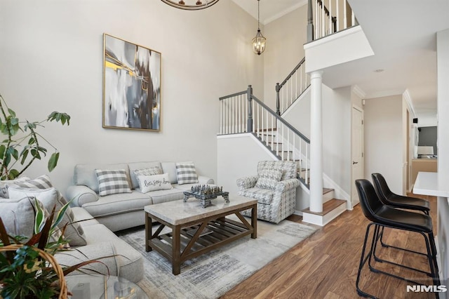 living room featuring a high ceiling, hardwood / wood-style flooring, and crown molding