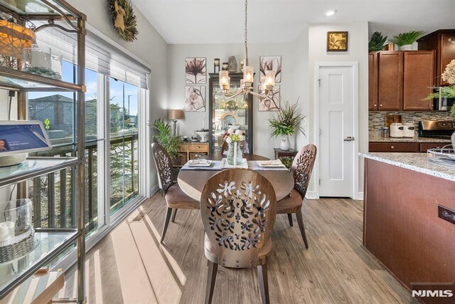 dining area featuring light hardwood / wood-style floors and an inviting chandelier