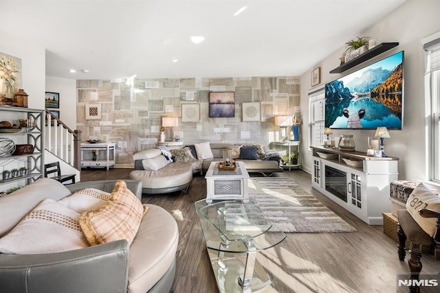 living room featuring hardwood / wood-style floors and tile walls