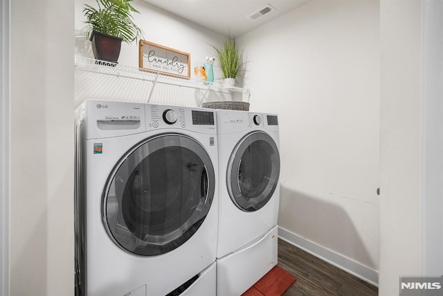 laundry room featuring separate washer and dryer and dark wood-type flooring