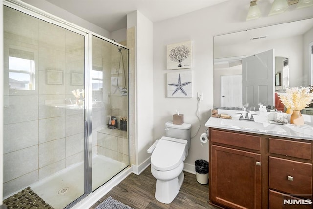 bathroom featuring vanity, toilet, wood-type flooring, and a shower with door