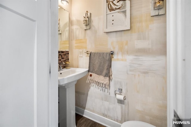 bathroom with decorative backsplash, sink, and hardwood / wood-style flooring