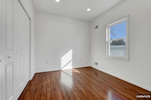 unfurnished bedroom featuring dark wood-type flooring and a closet