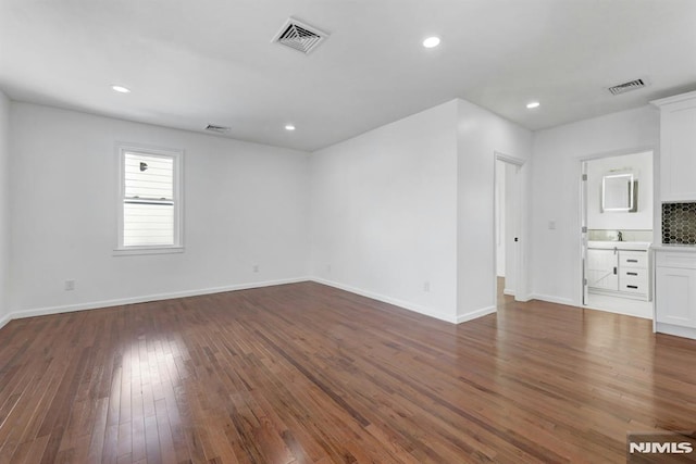 unfurnished living room with dark hardwood / wood-style flooring and sink