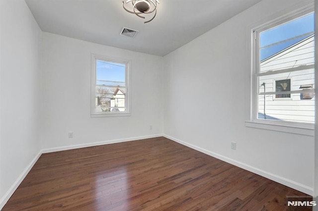 empty room with dark hardwood / wood-style flooring