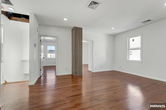 empty room featuring dark hardwood / wood-style flooring and beamed ceiling