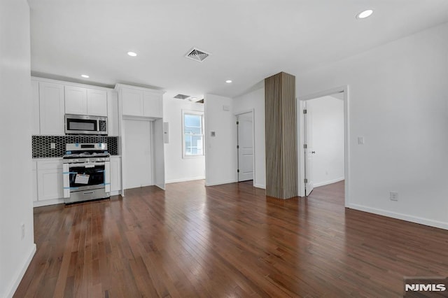 kitchen featuring backsplash, white cabinets, dark hardwood / wood-style flooring, and stainless steel appliances