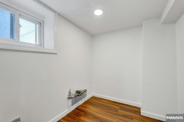 clothes washing area with hardwood / wood-style flooring