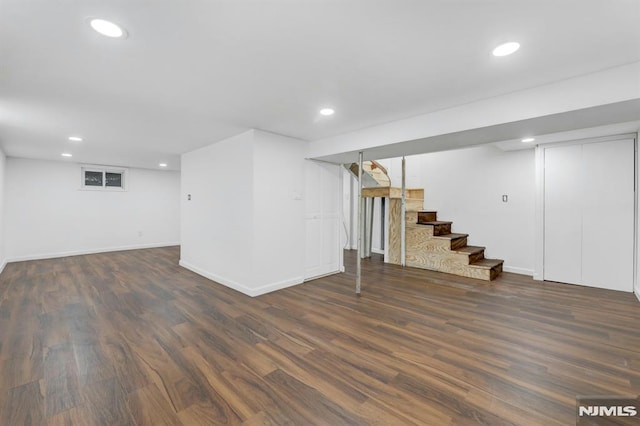 basement with dark hardwood / wood-style floors