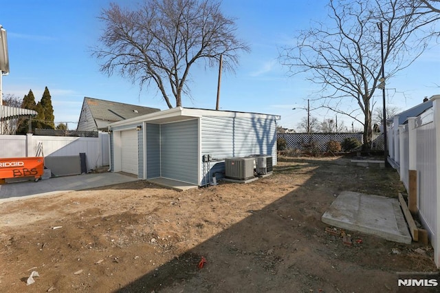 view of outdoor structure with cooling unit and a garage