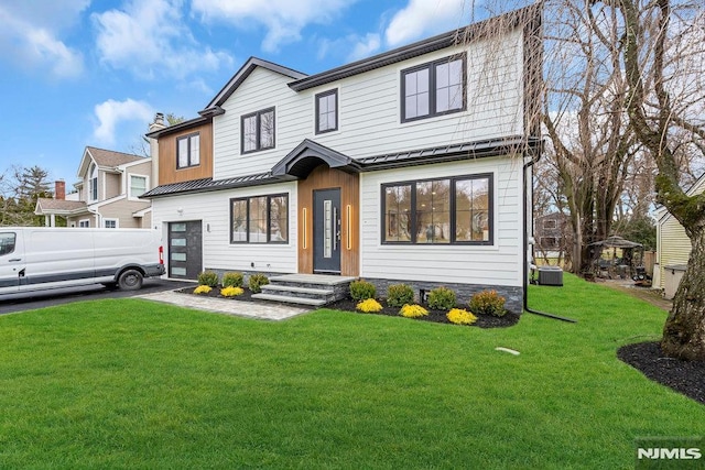 view of front of home with a front yard and central AC unit