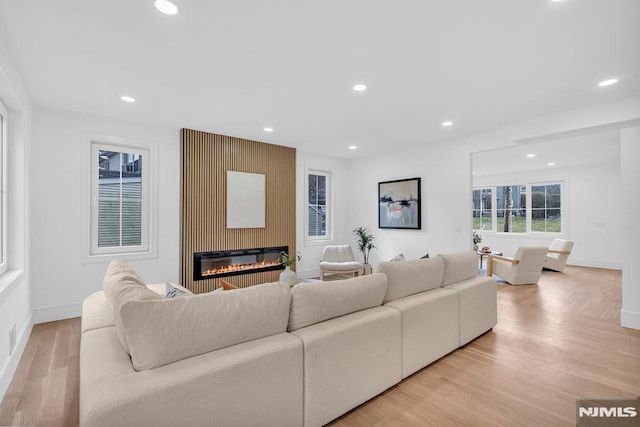 living room with a fireplace and light wood-type flooring