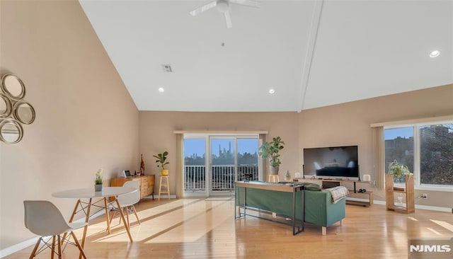 living room with ceiling fan, high vaulted ceiling, and light hardwood / wood-style flooring