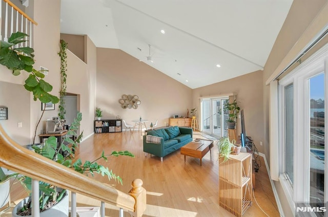 living room with hardwood / wood-style floors, ceiling fan, and vaulted ceiling