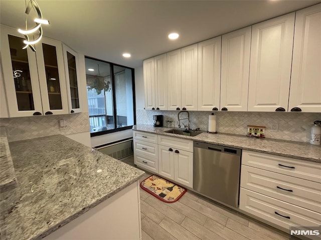 kitchen featuring pendant lighting, sink, stainless steel dishwasher, light stone countertops, and white cabinetry