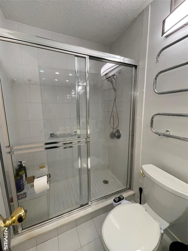 bathroom featuring tile patterned floors, a shower with door, a textured ceiling, and toilet