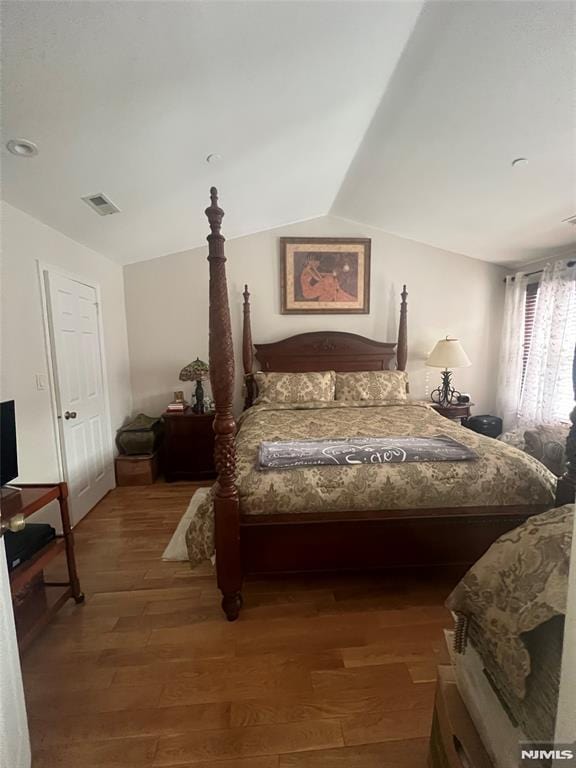 bedroom with lofted ceiling and wood-type flooring