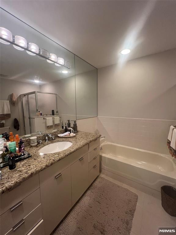 bathroom with shower with separate bathtub, vanity, and tile patterned flooring