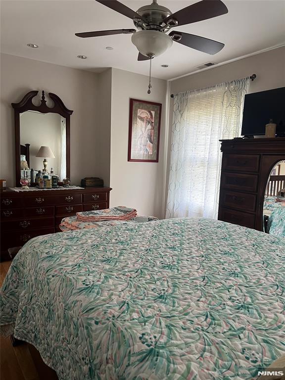 bedroom with ceiling fan and wood-type flooring