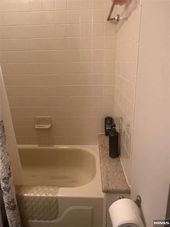 bathroom with toilet and shower / bathtub combination with curtain