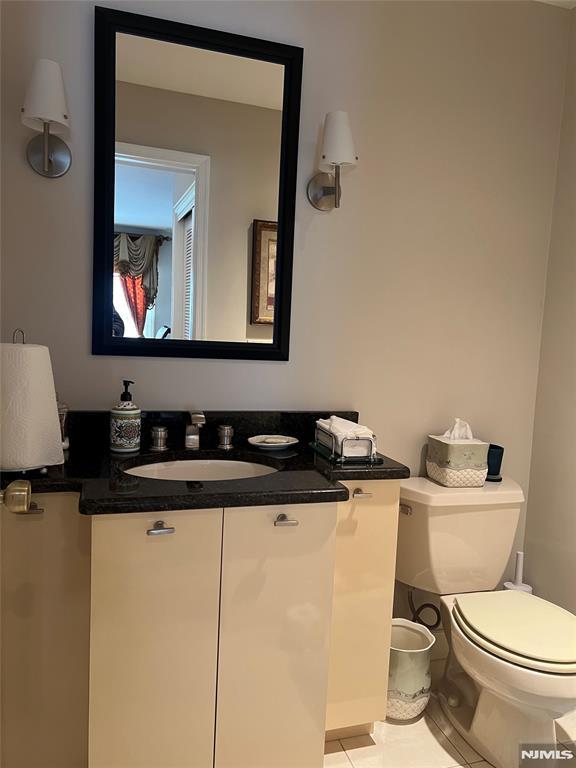 bathroom with vanity, tile patterned floors, and toilet