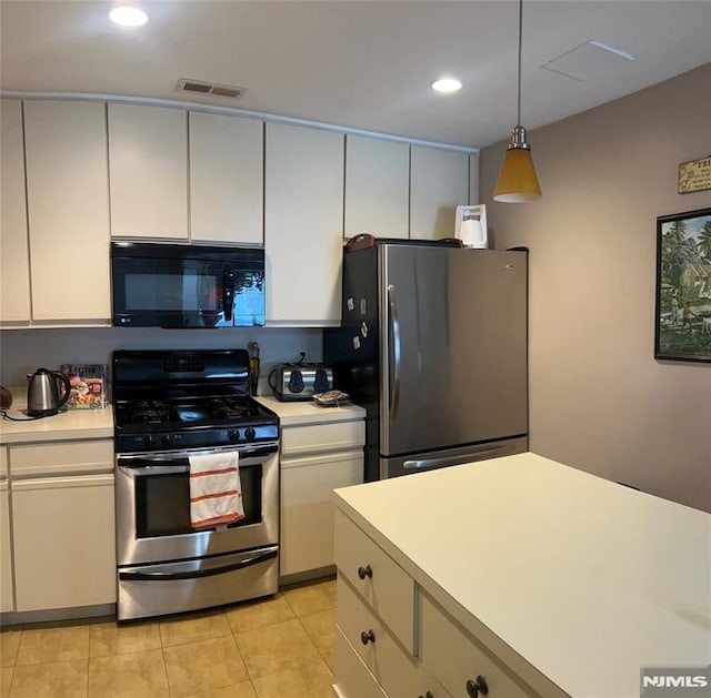 kitchen with decorative light fixtures, light tile patterned floors, white cabinets, and appliances with stainless steel finishes