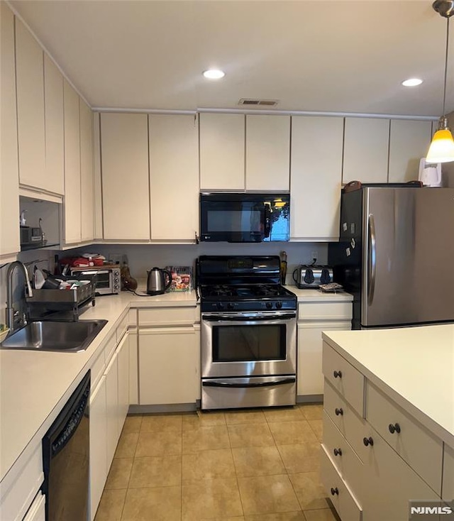 kitchen with sink, white cabinetry, light tile patterned flooring, hanging light fixtures, and appliances with stainless steel finishes