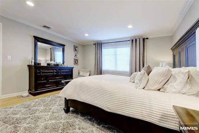 bedroom with light wood-type flooring and crown molding