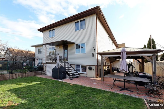 back of property featuring a gazebo, a yard, and a patio area