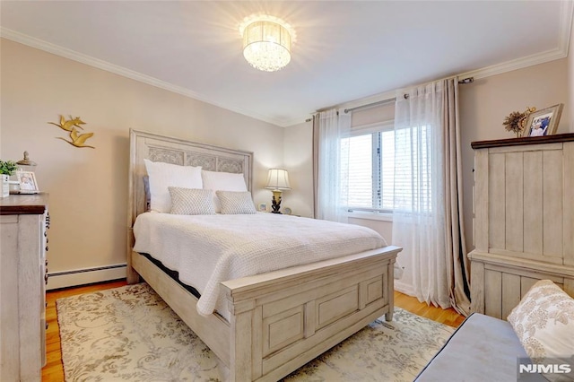 bedroom featuring light hardwood / wood-style flooring, ornamental molding, and a baseboard heating unit