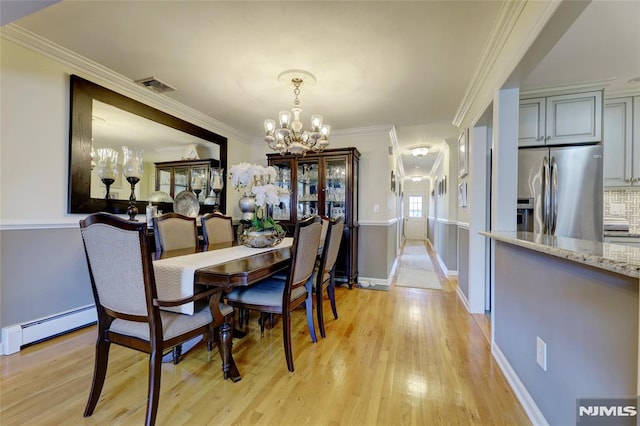 dining space with a baseboard radiator, crown molding, a notable chandelier, and light hardwood / wood-style floors